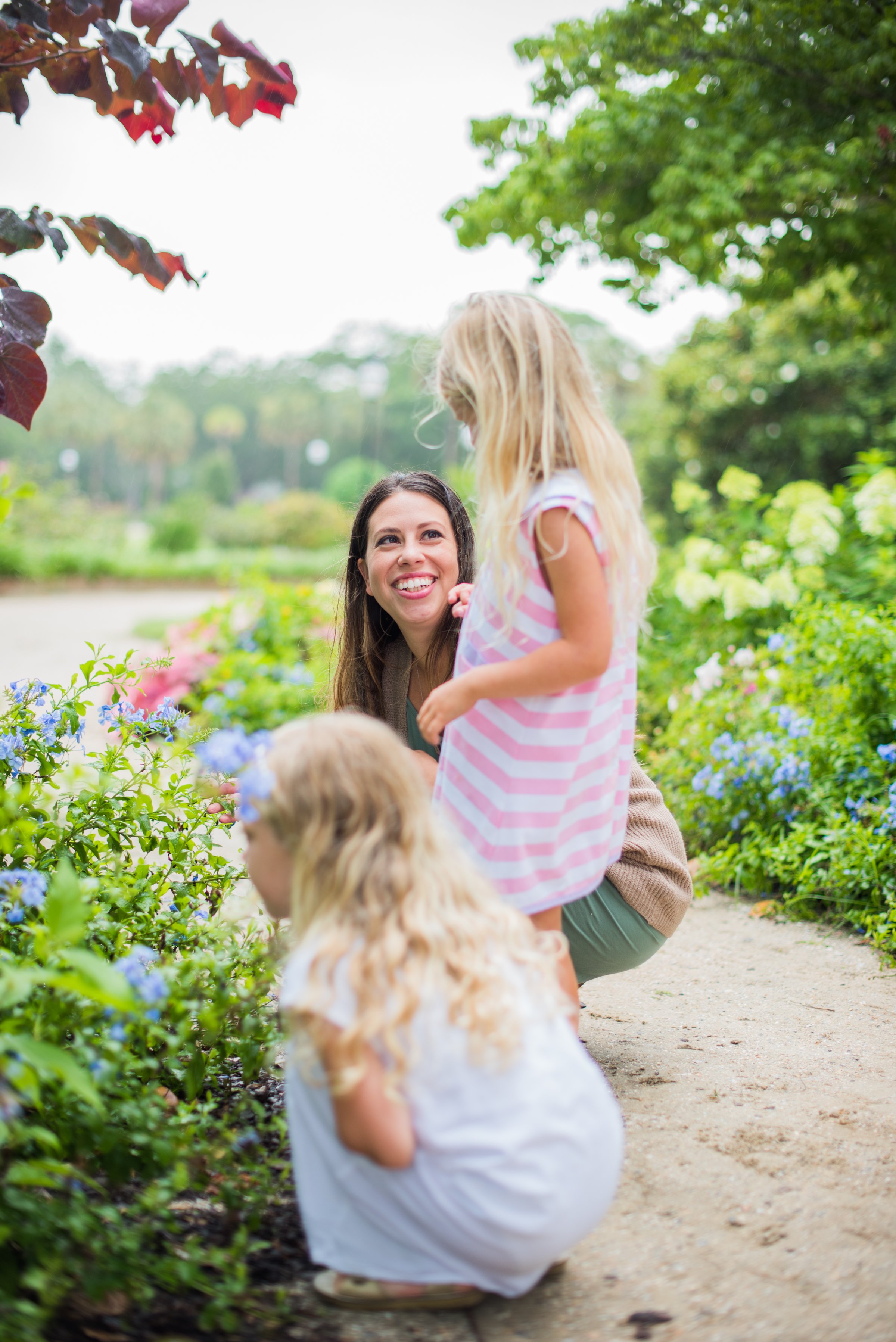 Nanny sitting in a garden with two little girls