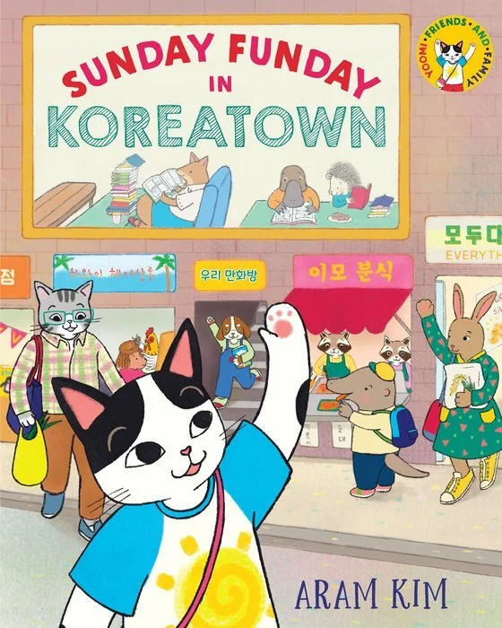 Book cover. A cartoon cat in a T-shirt gestures toward a sign of animals reading that says "Sunday Funday in Koreatown." Behind her, several cartoon animals buy and sell items at a market with signs in Hangul. The bottom reads "Aram Kim."