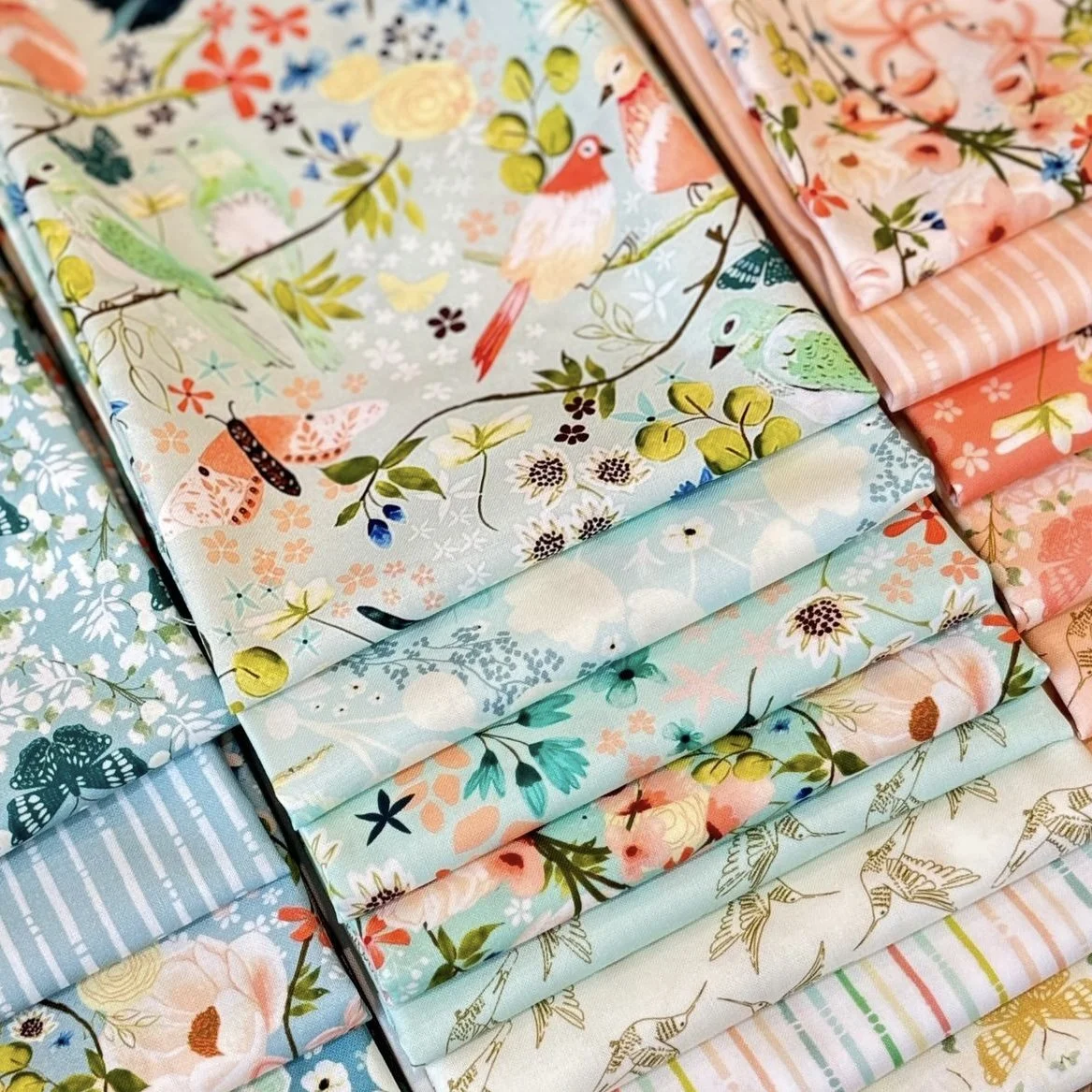 Serenity Blooms Fabric by Ginger Deverell with birds, flowers, butterflies, in soft pastel peaches mints and blue colours