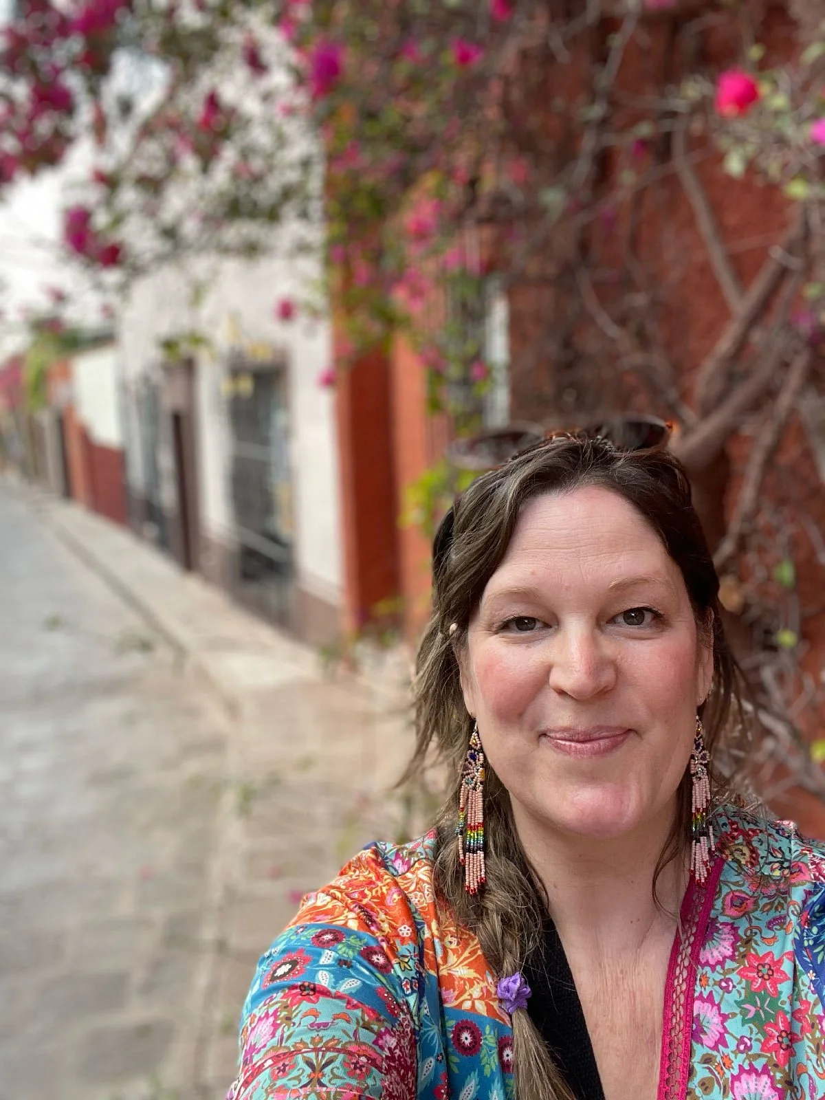Ginger in front of bougenvalia flowers in a narrow cobblestone street in San Miguel de Allende Mexico