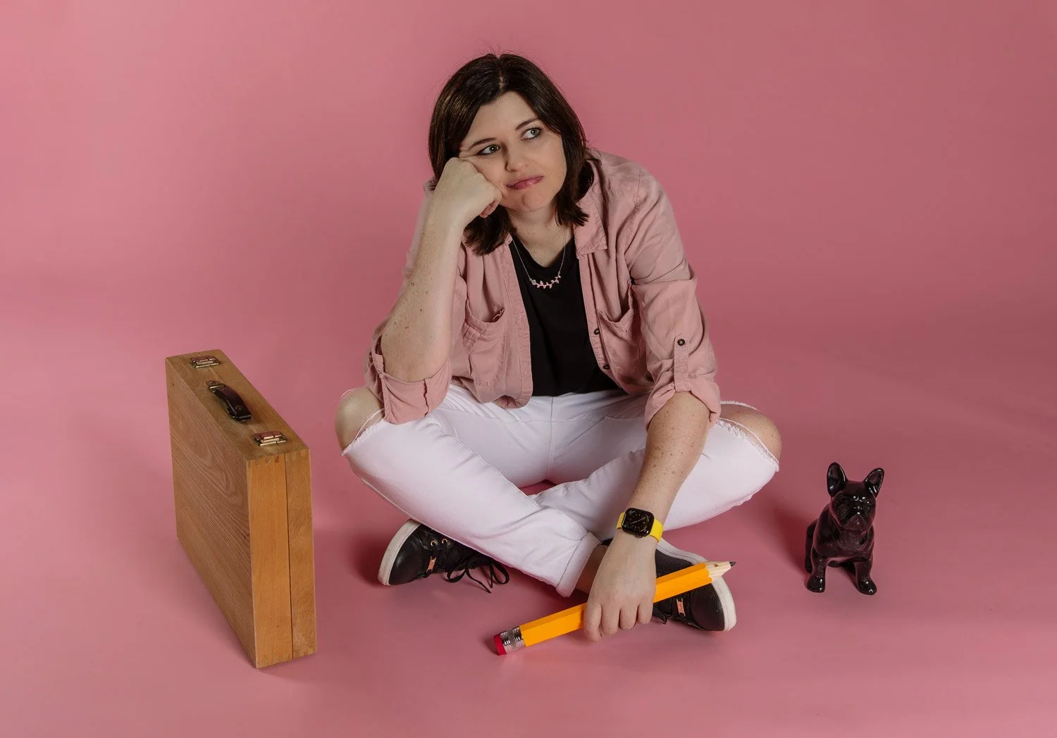 Amy Slatem looking at bored holding pencil on pink background