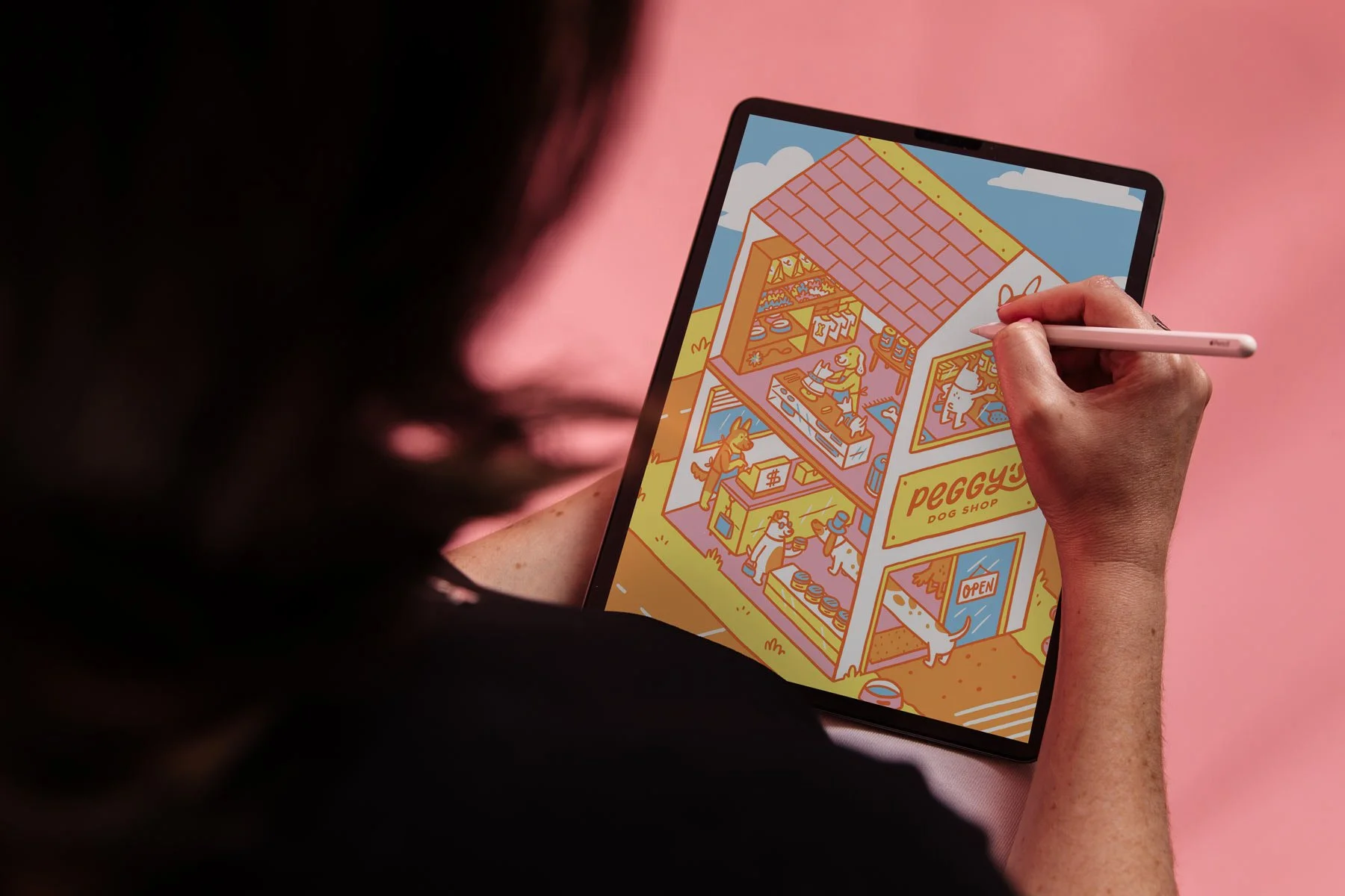 Image of Amy drawing on an ipad with an isometric dog house on screen
