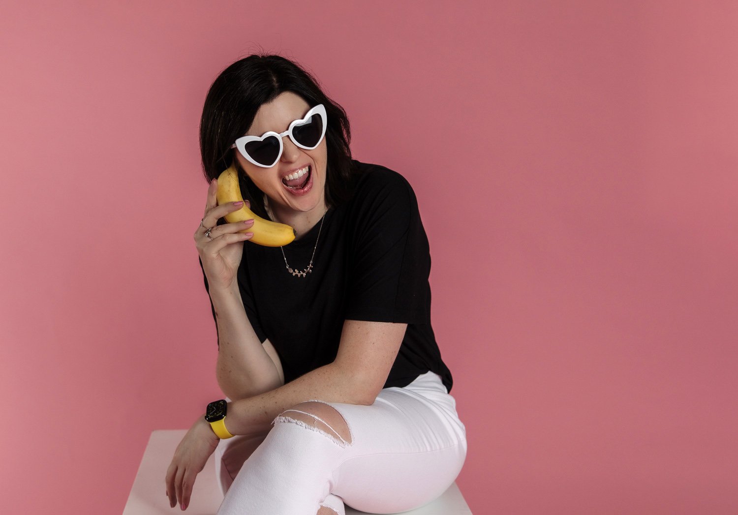 Photo of Amy on a banana phone call against a pink background