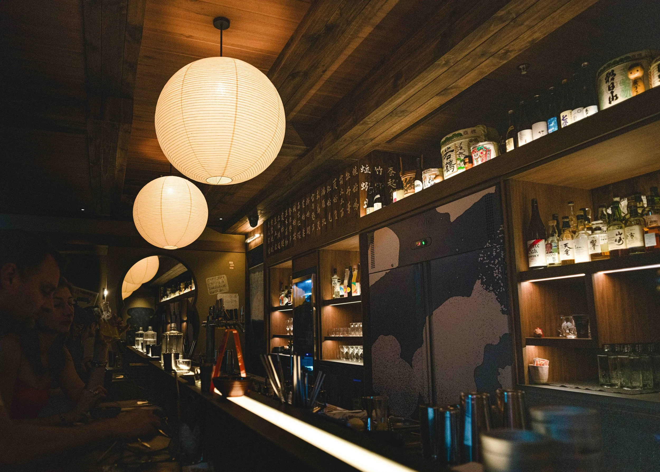 The bar at Sekura House, with spherical paper lanterns hanging above