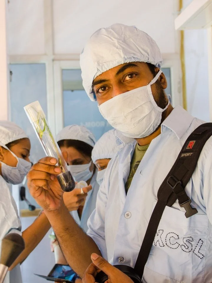 Lab technicians in protective clothing holding test tubes