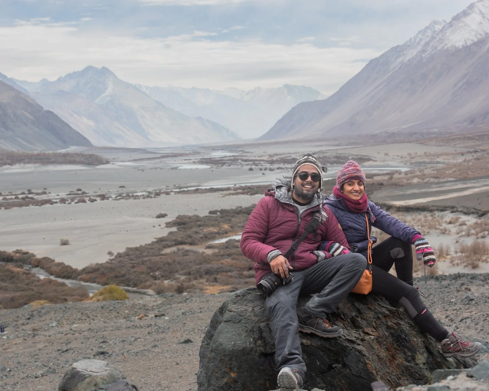 Csitting on rock in mountainous valley with snow-capped peaks of Leh-Ladakh region of India.