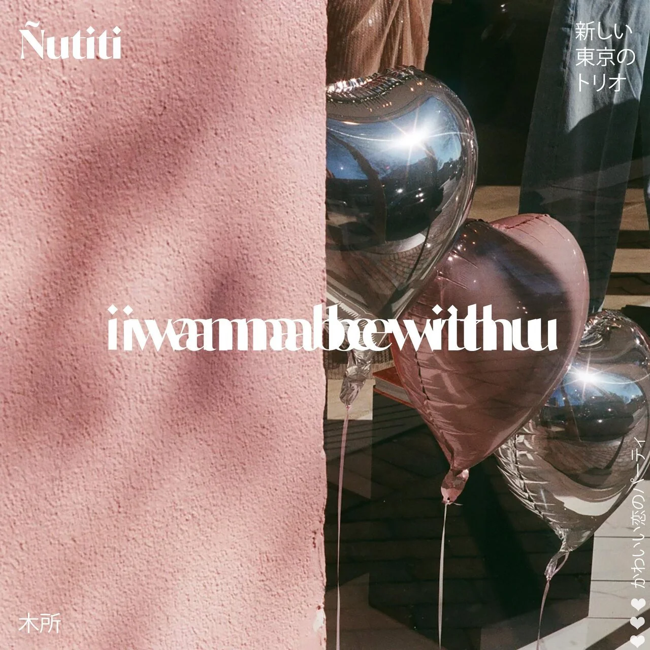 Pink textured wall with silver and pink heart-shaped balloons behind it.