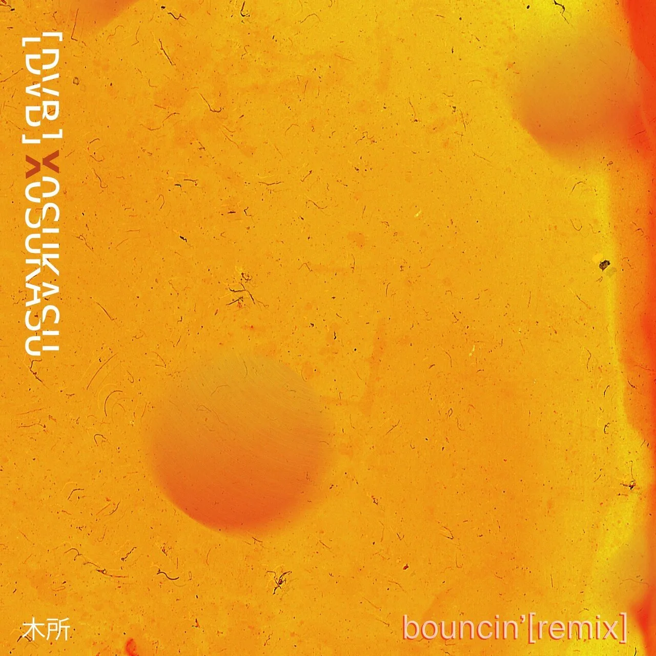 Close-up of a yellow-orange textured surface with small dots and scratches, featuring text in Japanese and English that reads 'antiyasu-1 兒灰粉' and 'bouncin'[remix].