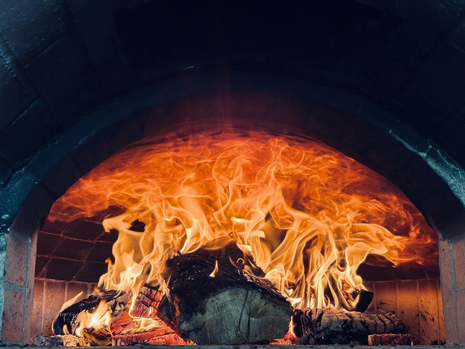 Custom traditional brick pizza oven handcrafted with fire-rated bricks and authentic masonry techniques, designed for high-heat performance and long-lasting durability. This classic wood-fired pizza oven delivers even heat distribution, artisanal coo