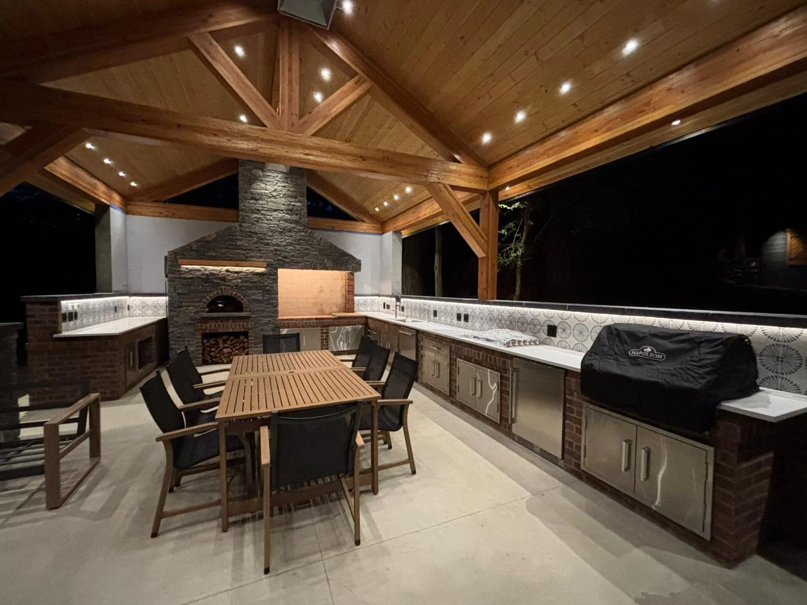Custom outdoor kitchen designed for year-round entertaining, featuring built-in appliances, durable countertops, storage, and high-quality masonry finishes. Professionally built for long-lasting performance, this outdoor living space enhances functio