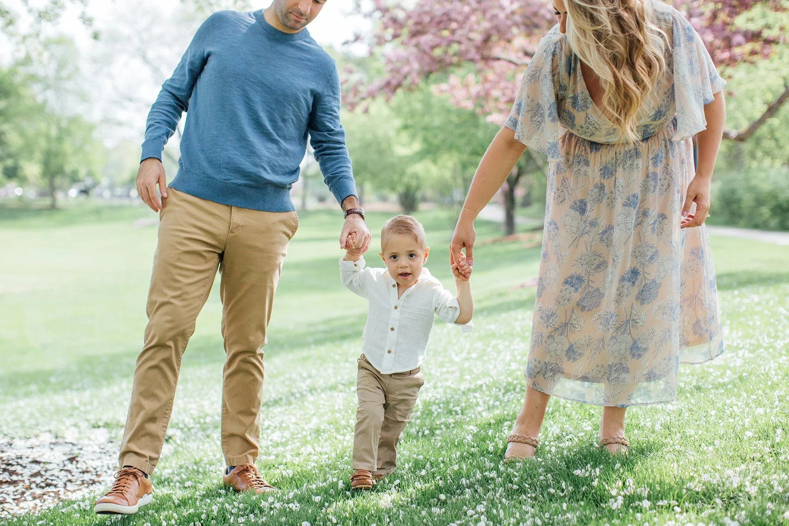 Family walking along the Naperville Riverwalk covered bridge during a spring family photo session