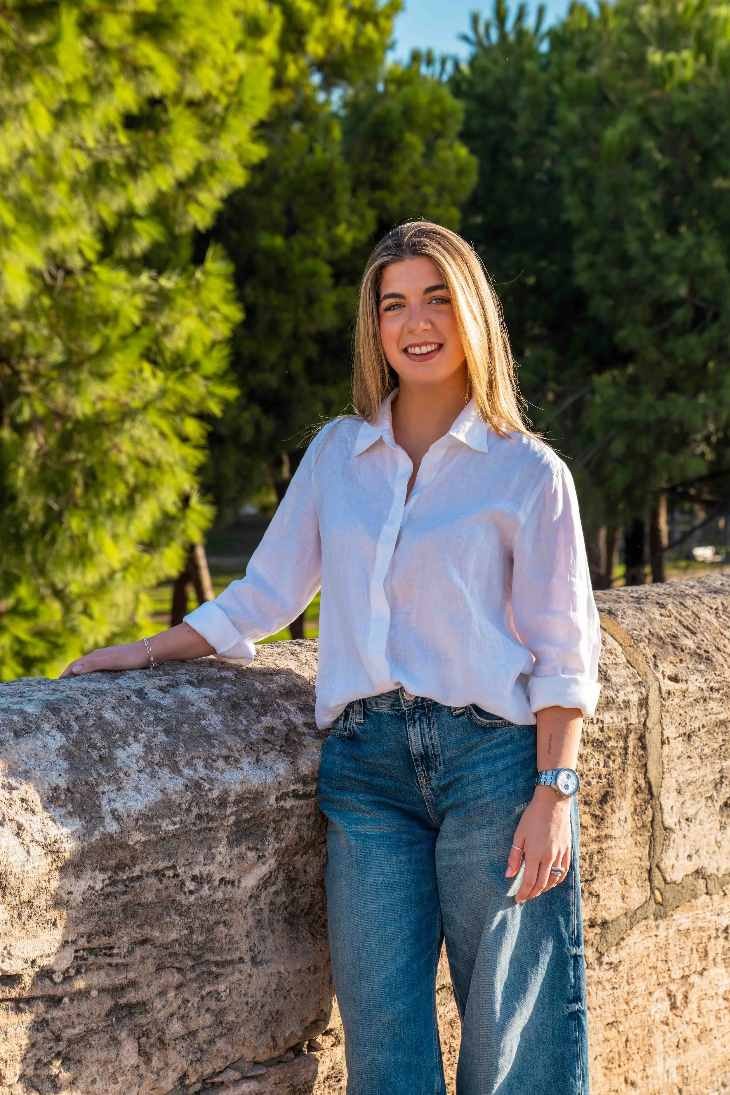 Anna Izquierdo, operations and client support at Encantada World, leaning on a stone wall in Valencia
