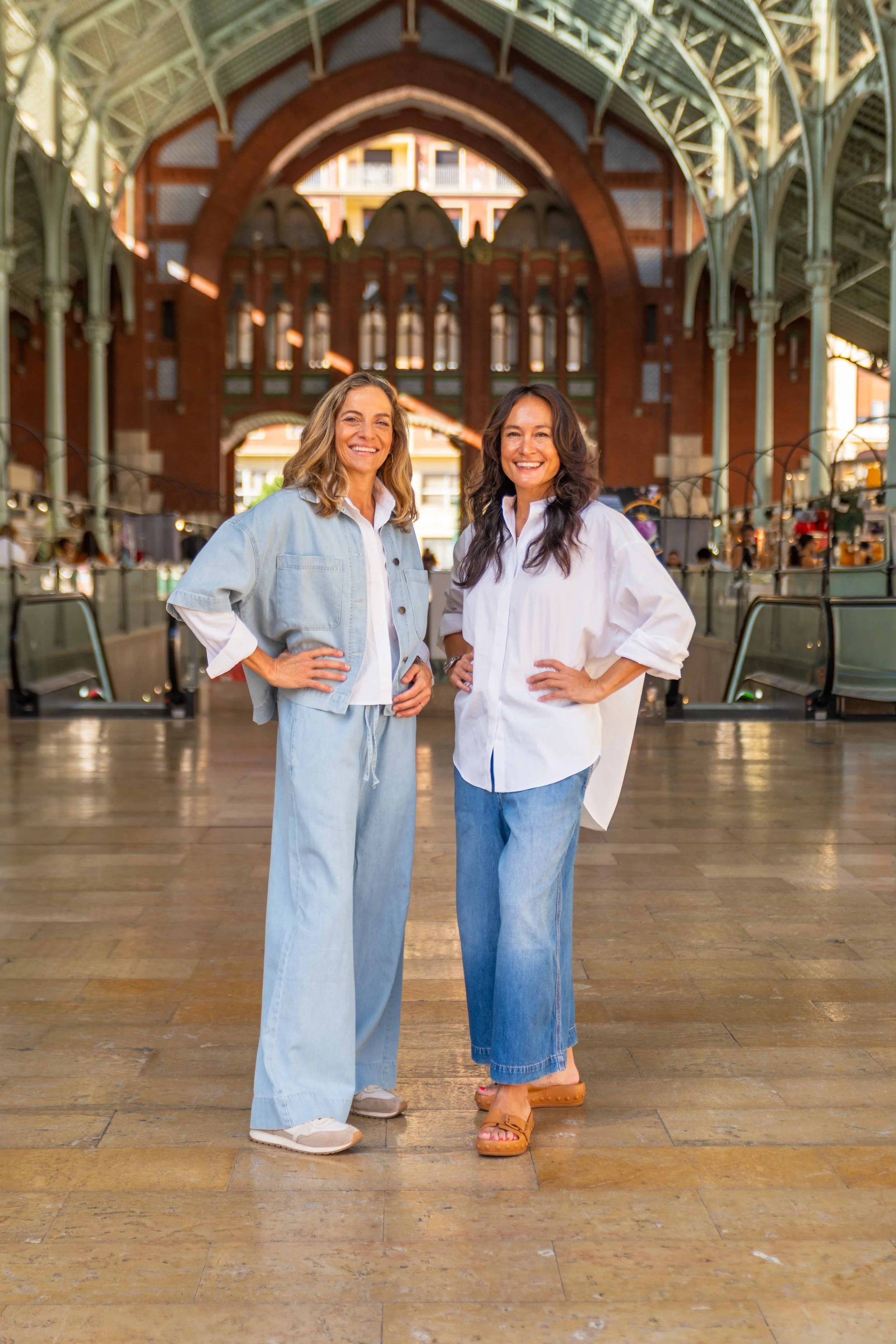 Maria and Stephanie, founders of Encantada World, standing together inside Valencia's Mercado de Colón