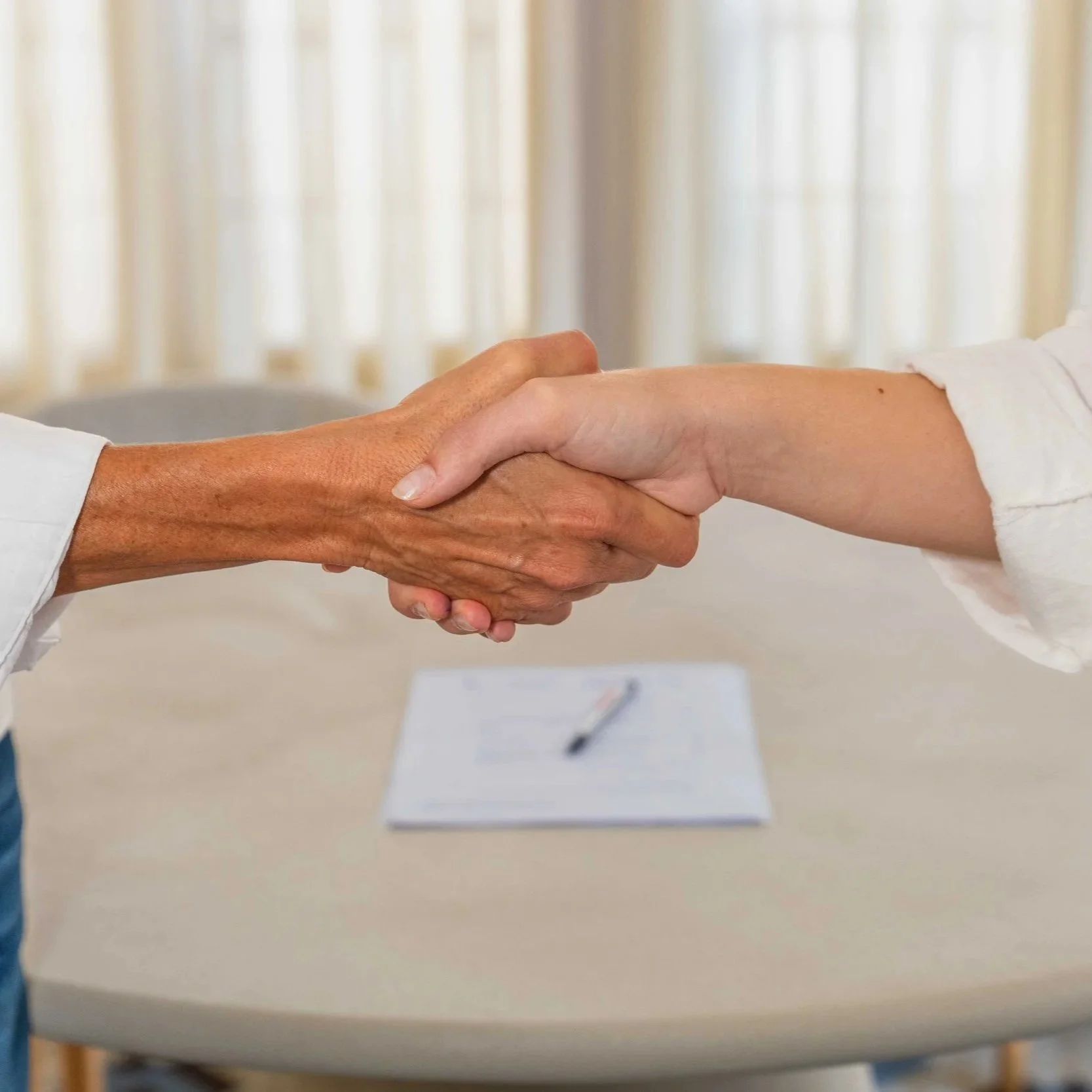 A client and Encantada World's legal team shaking hands over a signed property contract in Valencia