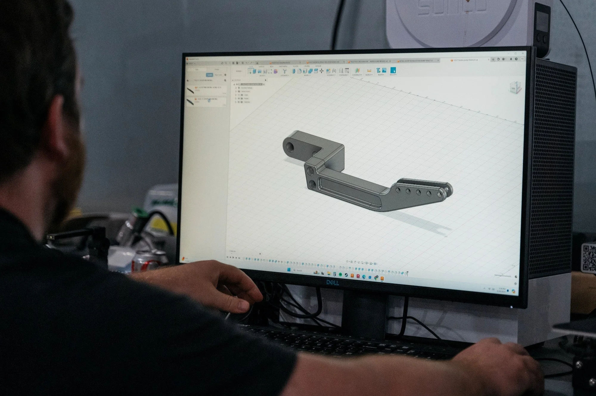 Person working on a computer designing a mechanical part in CAD software.