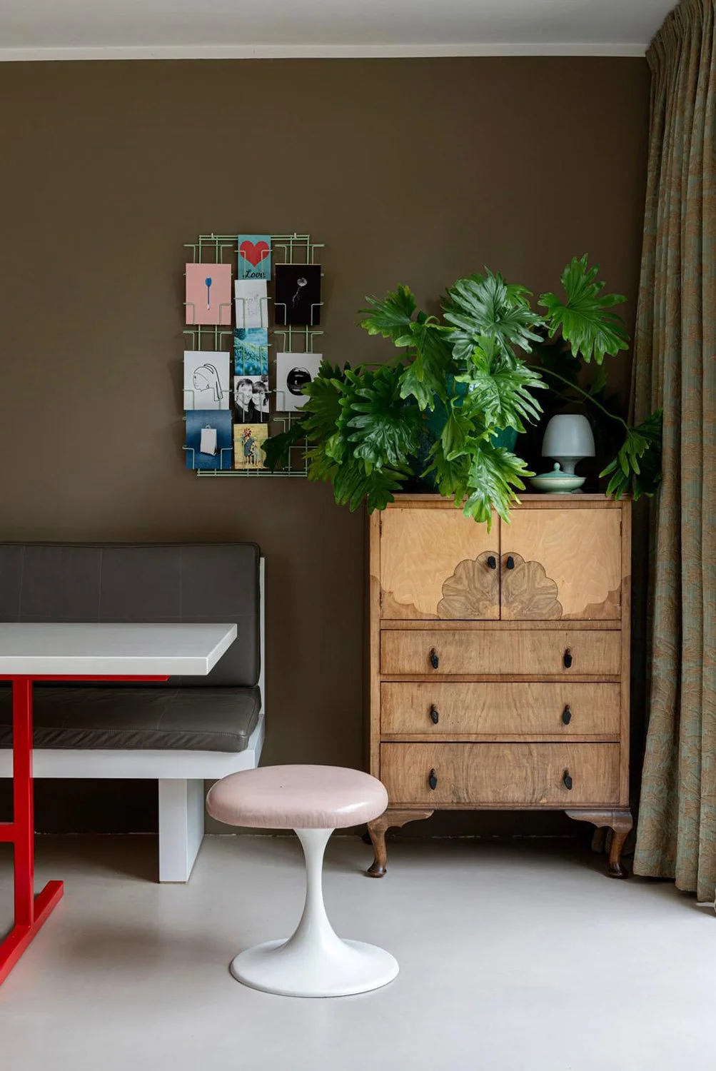 CharlotteMixt interieurontwerp Vught. VTWonen shoot thuis bij Charlotte Rijk. Vintage stoel, met plant en fotocollage, bruine muur, witte tafel met rood onderstel. Mixen van stijlen in je interieur.
