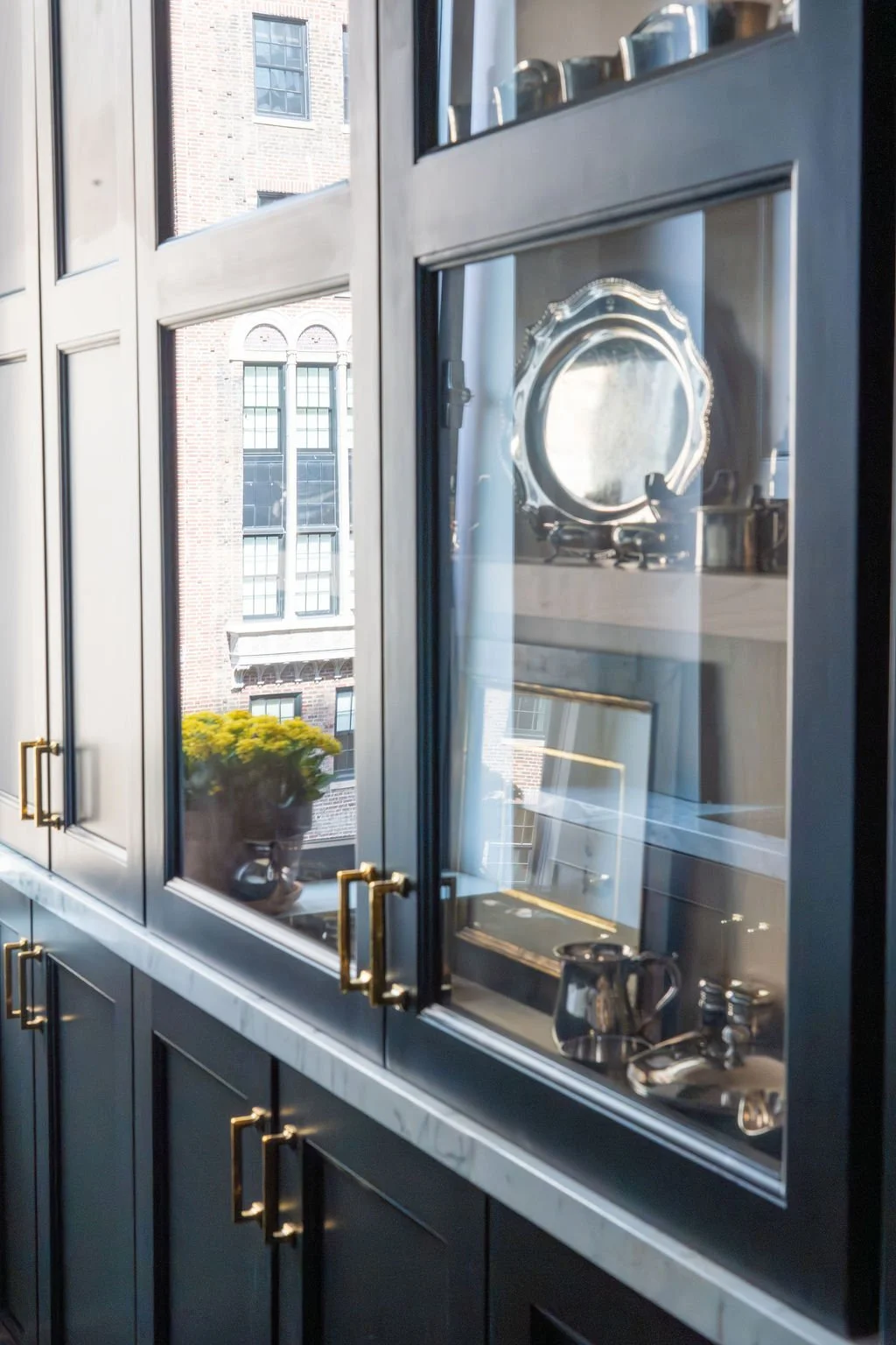 Custom glass-front cabinetry and integrated lighting by RI Architecture