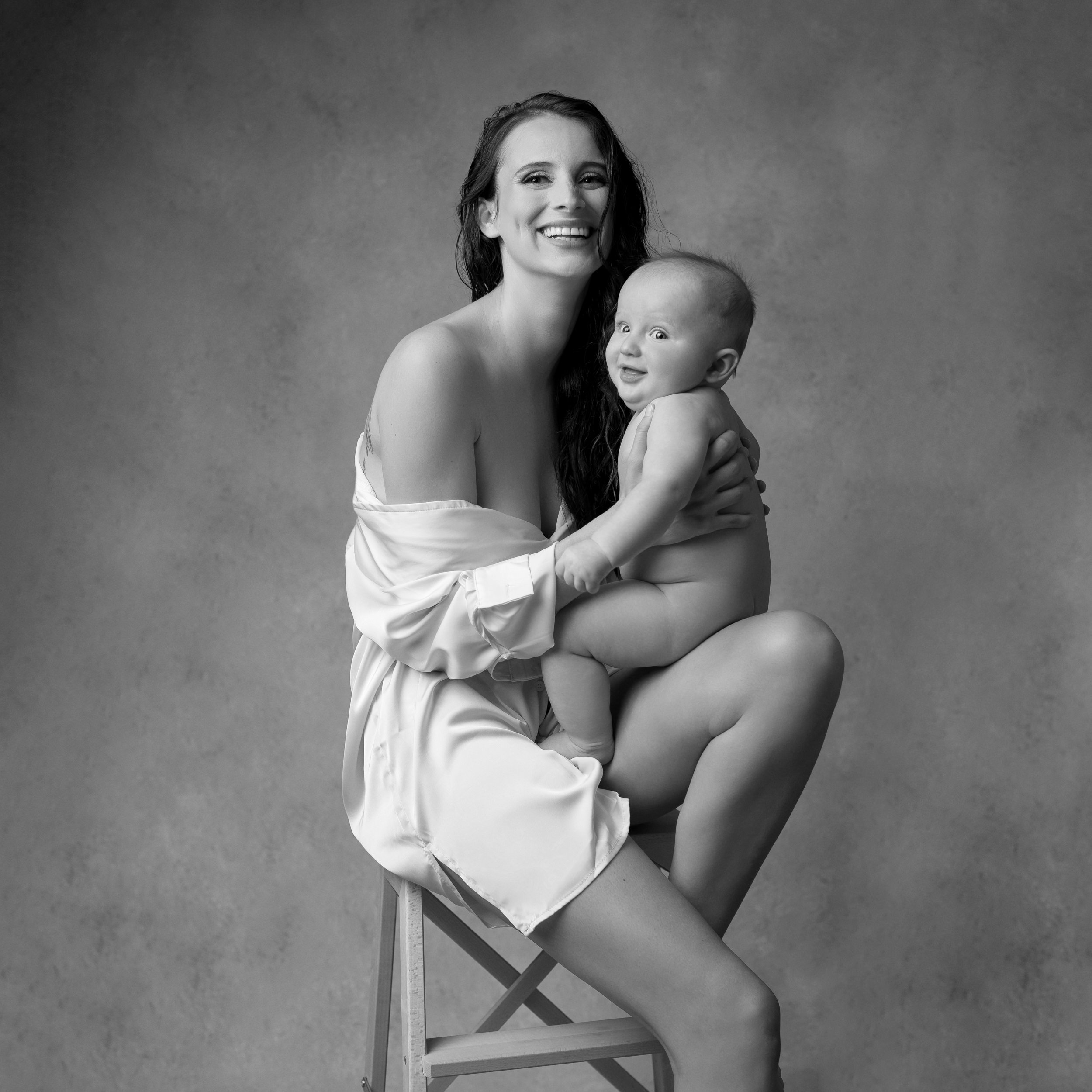 motherhood-photoshoot-with-over-sized-white-collar-shirt-with-wet-hair-holding-her-baby.jpg