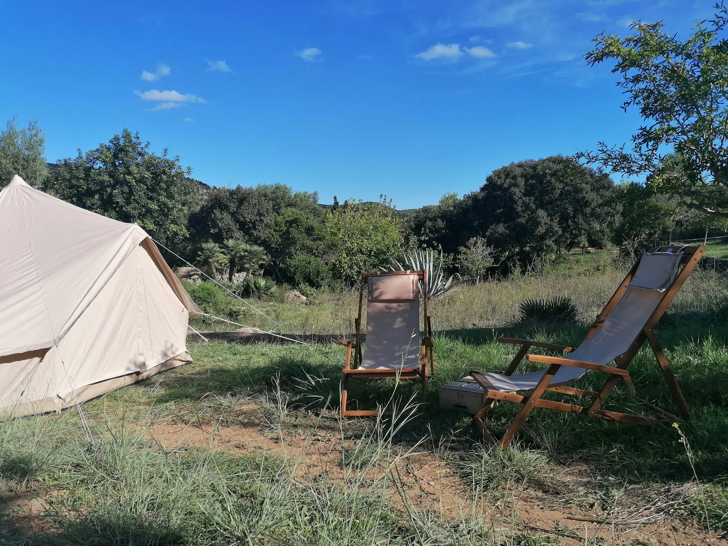 Bell tent with relaxing outdoor seating, set up at a private property in Mallorca.