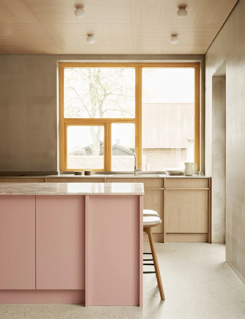 Bespoke light oak kitchen with a soft pink island and matching pink marble worktop.