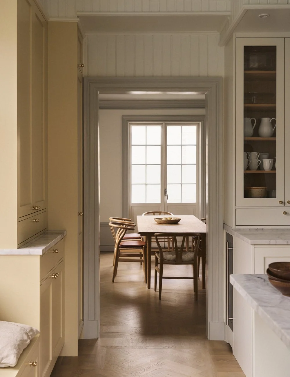 Dining room in a Swedish 1910s home with high ceilings, large windows, tongue-and-groove panelling and decorative joinery.