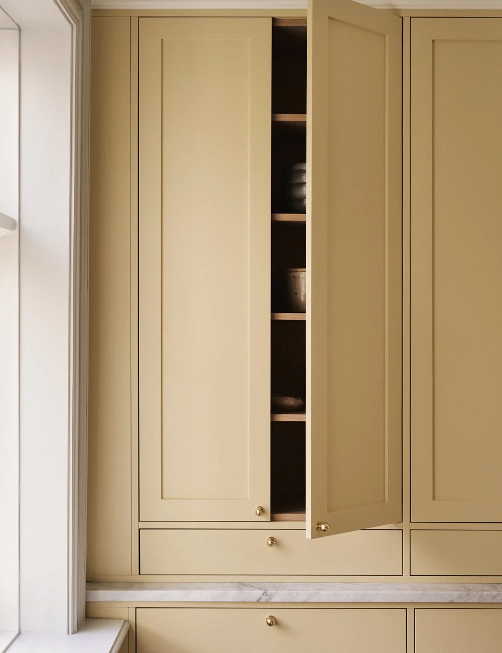 Bespoke yellow Shaker kitchen cabinet with a natural oak interior.