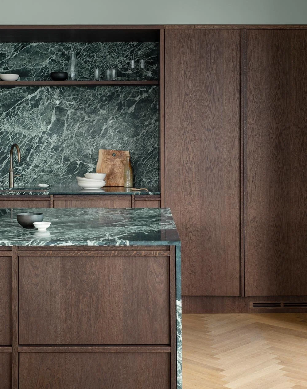The elegant wooden kitchen with green marble