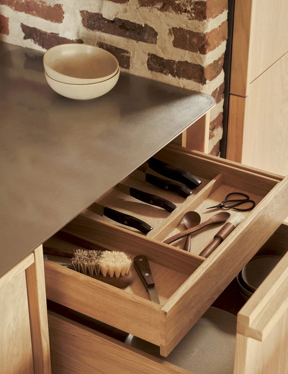 Light oak kitchen with solid oak handle rails and solid wood drawers.