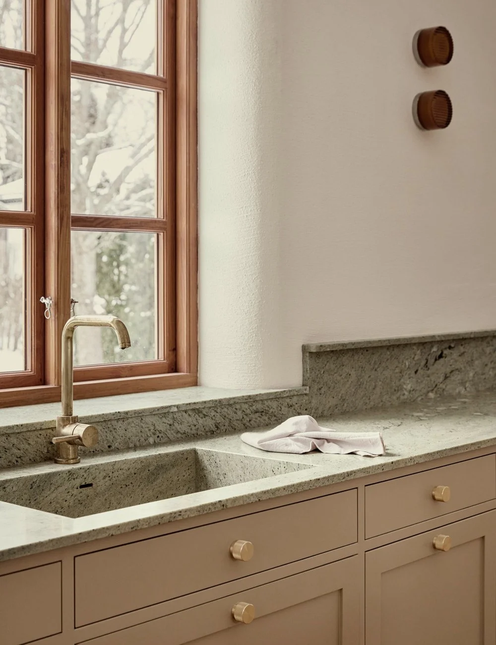 Classic beige Shaker kitchen with patterned Lemon Ice granite worktop and brass details.