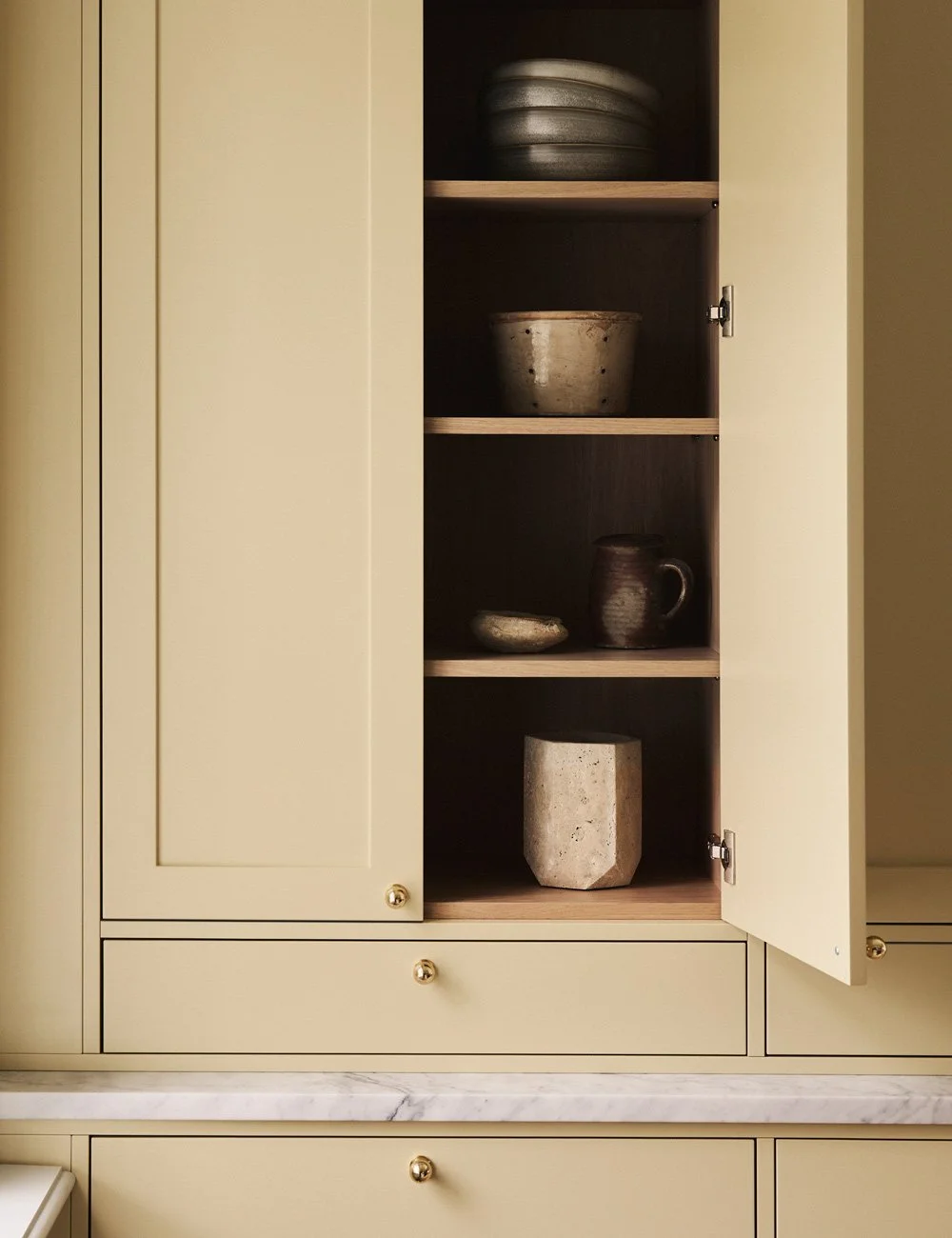 Soft butter yellow kitchen cabinetry bringing warmth and subtle colour to a bespoke kitchen.