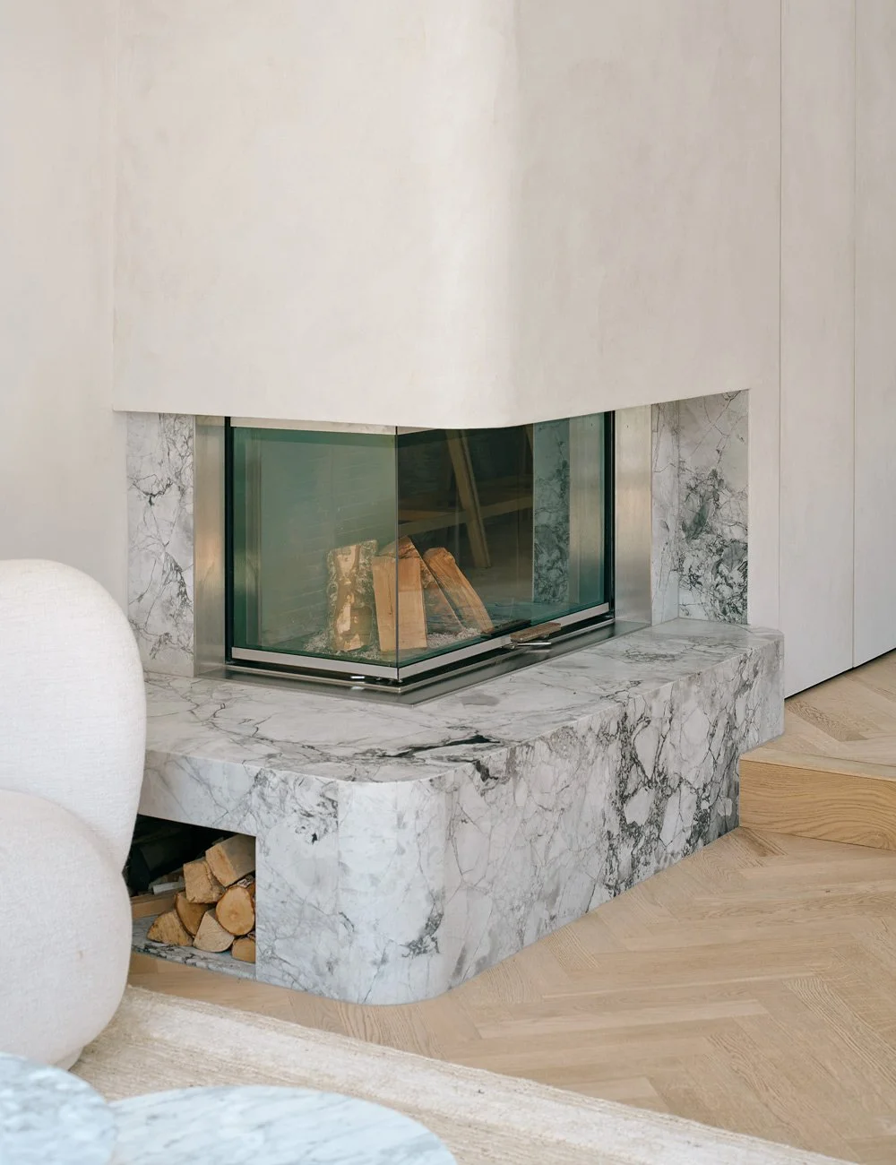 Marble fireplace connecting the kitchen and living area in a renovated London townhouse.
