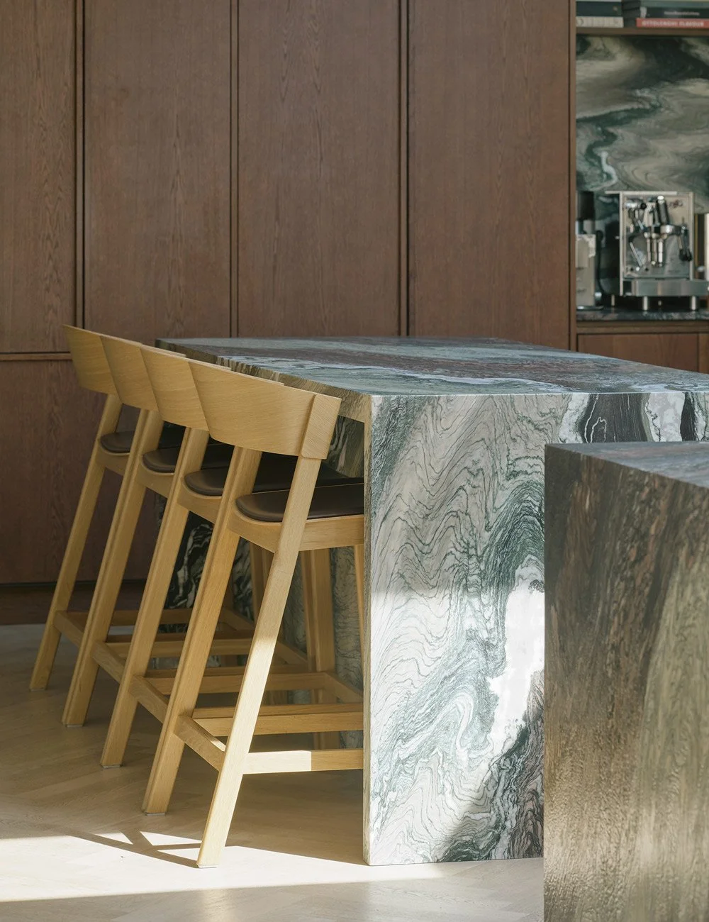 Bespoke marble kitchen island with Muuto Cover bar stools in a contemporary Scandinavian kitchen.