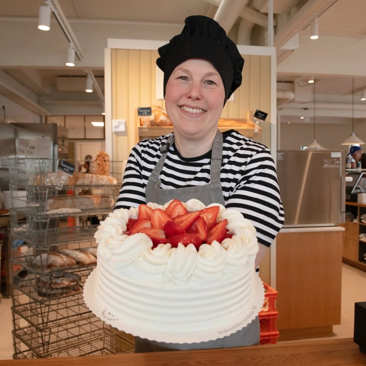 Jemina Siven Kontion leipomossa kädessään mansikkakermakakku