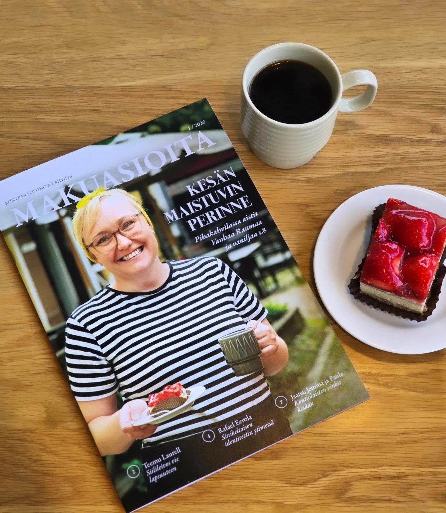 Kontion makuasioita-lehti, kuppi kahvia ja mansikkaleivos