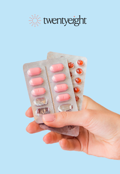 Hand holding two blister packs of pink and orange pills against a light blue background with 'twentyight' logo.