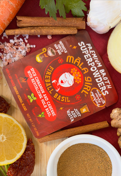Package of Malai Basil flavorful seasoning mix surrounded by garlic, lemon, cinnamon sticks, chili flakes, and assorted spices.