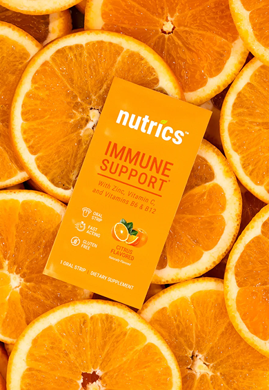 A box of Nutric's immune support dietary supplement placed on a bed of orange slices.