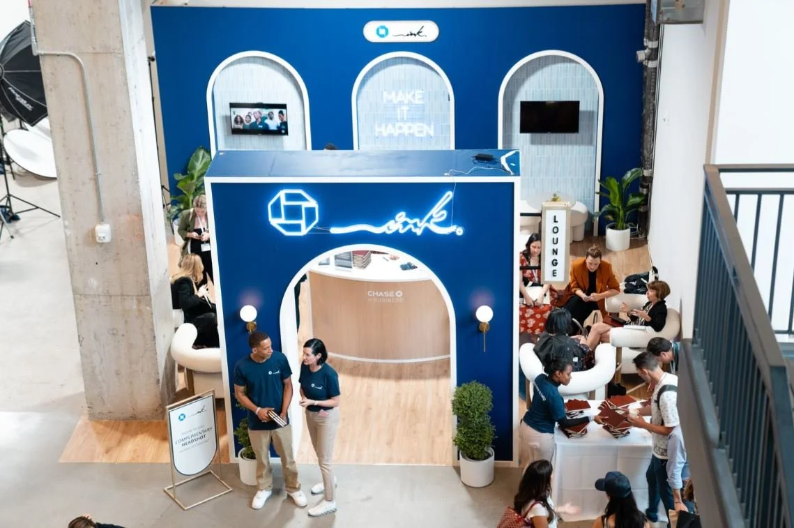 A stall at a trade show set up for Chase bank. There are two representatives standing in front of the stall.