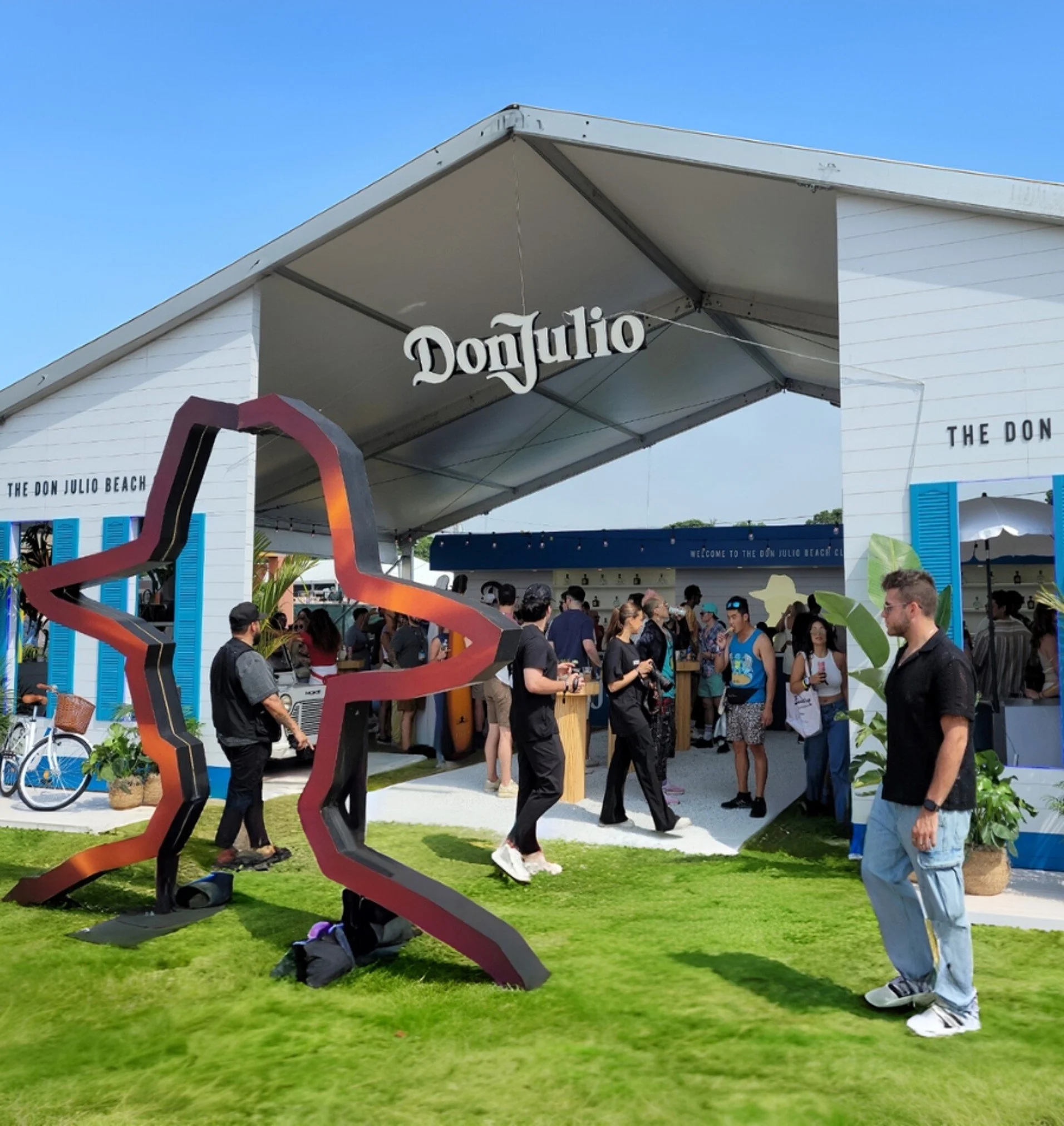 A large, outdoor pavilion covering a small trade show inside. There is a hanging sign that says "Don Julio."