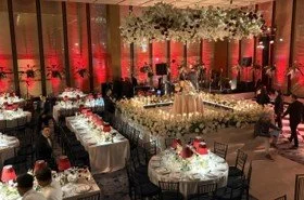 The interior of a wedding venue set up for a reception. There are multiple tables and chairs set up for dinner.