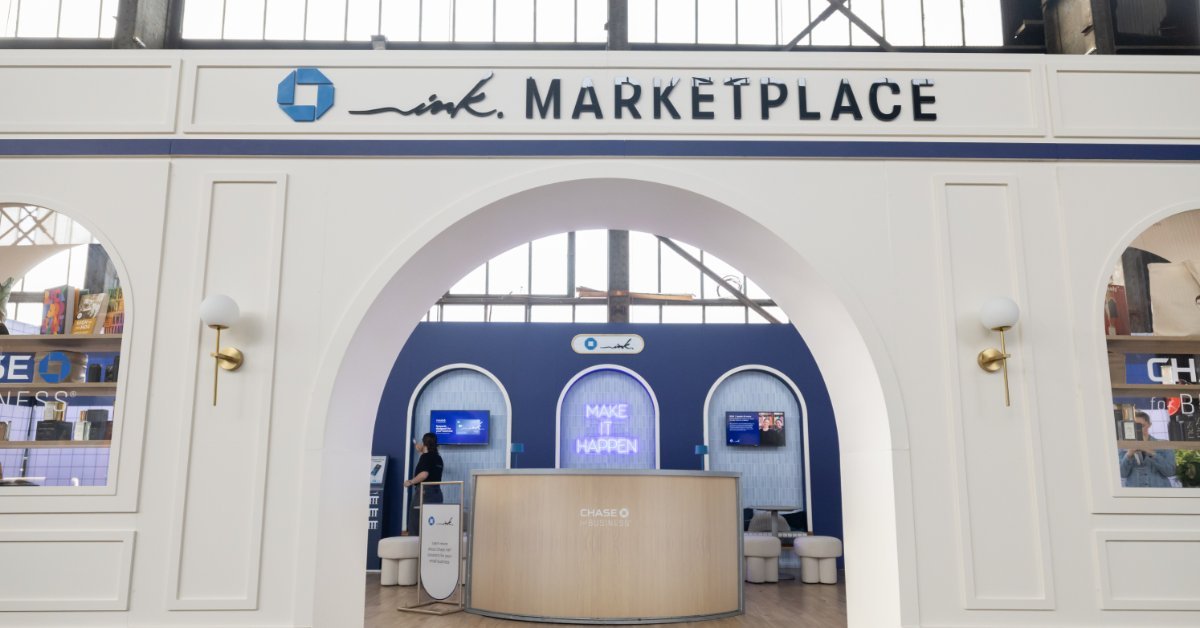 A white storefront display labeled “The Marketplace” with Onward signs, arched windows, shelves, and a counter.