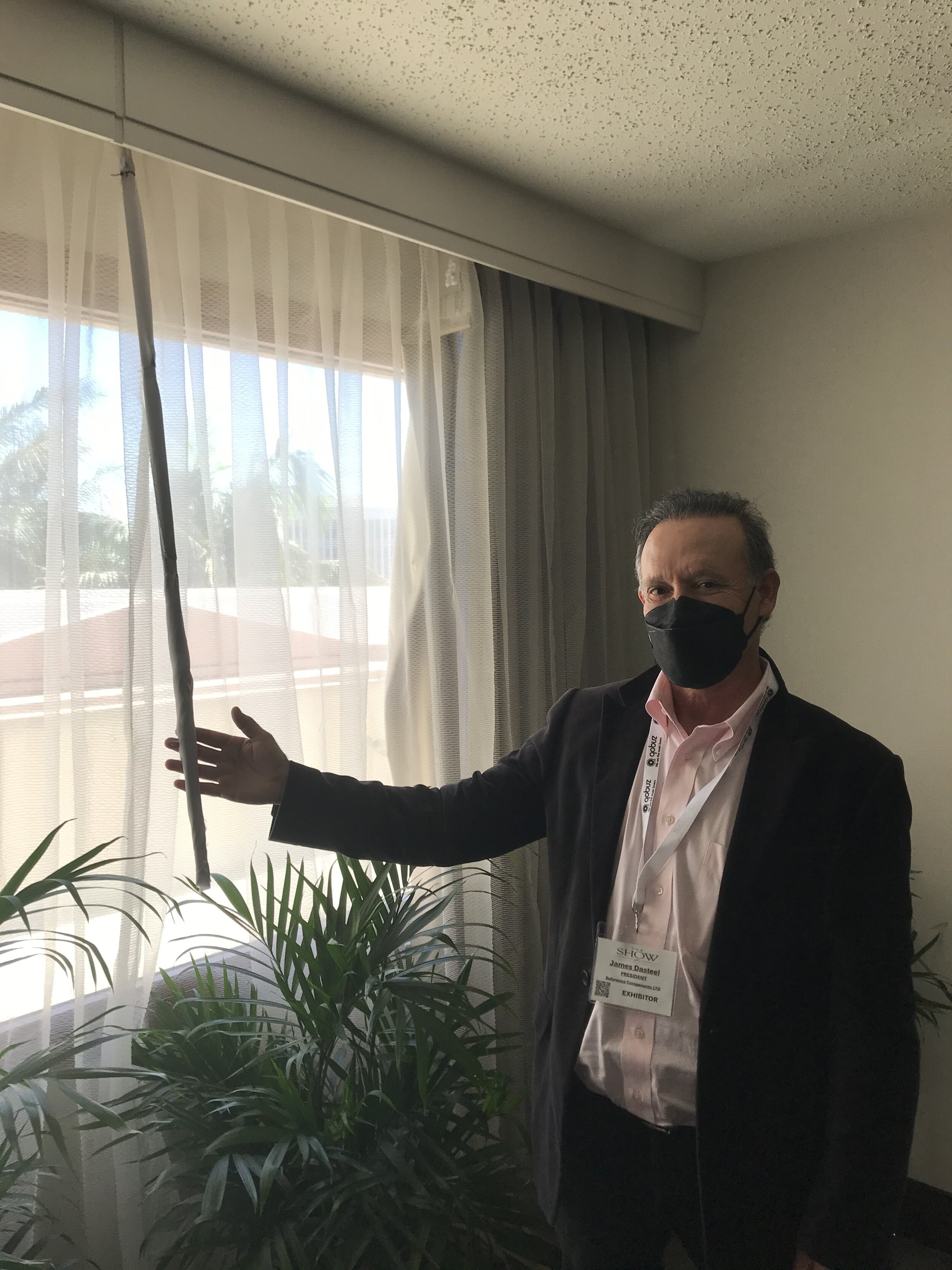 Jim Dasteel holding the silk-wrapped curtain rod