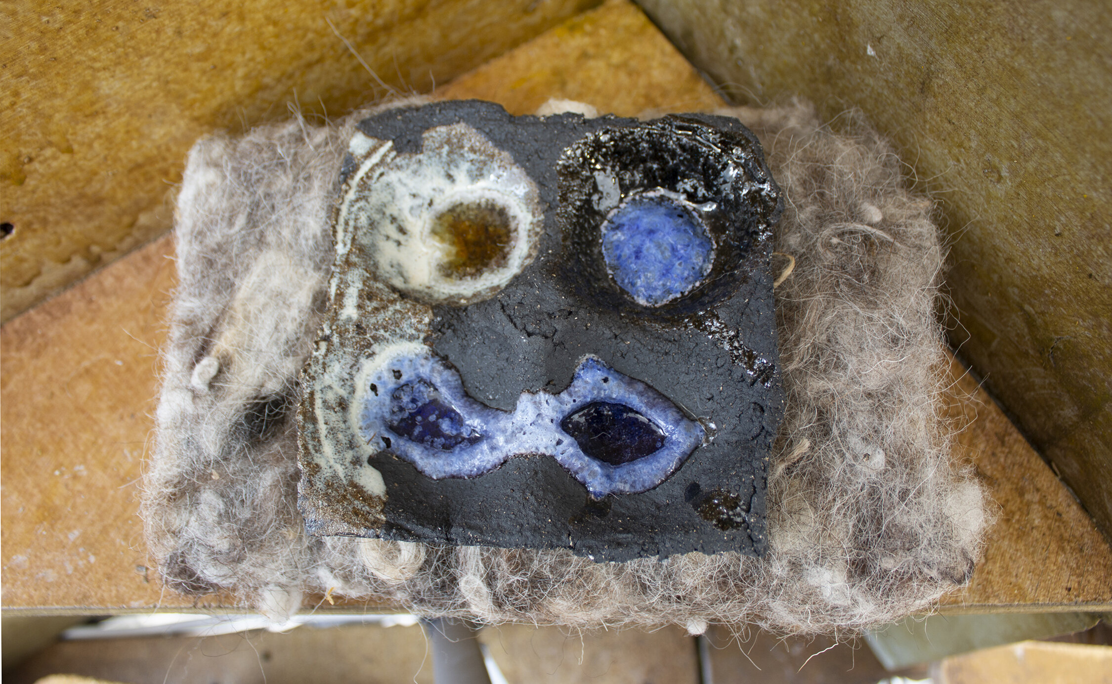 Pockets, stoneware, black crank clay, glaze and glass, 3cm x 13cm x 13cm, 2021, May Hands