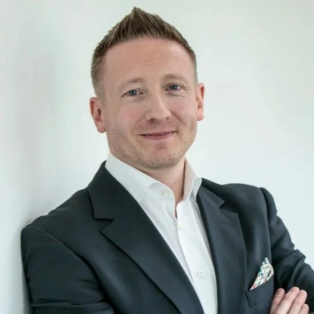 image of a man - gareth lockwood in a grey suit jacked and white shirt smiling at the camera