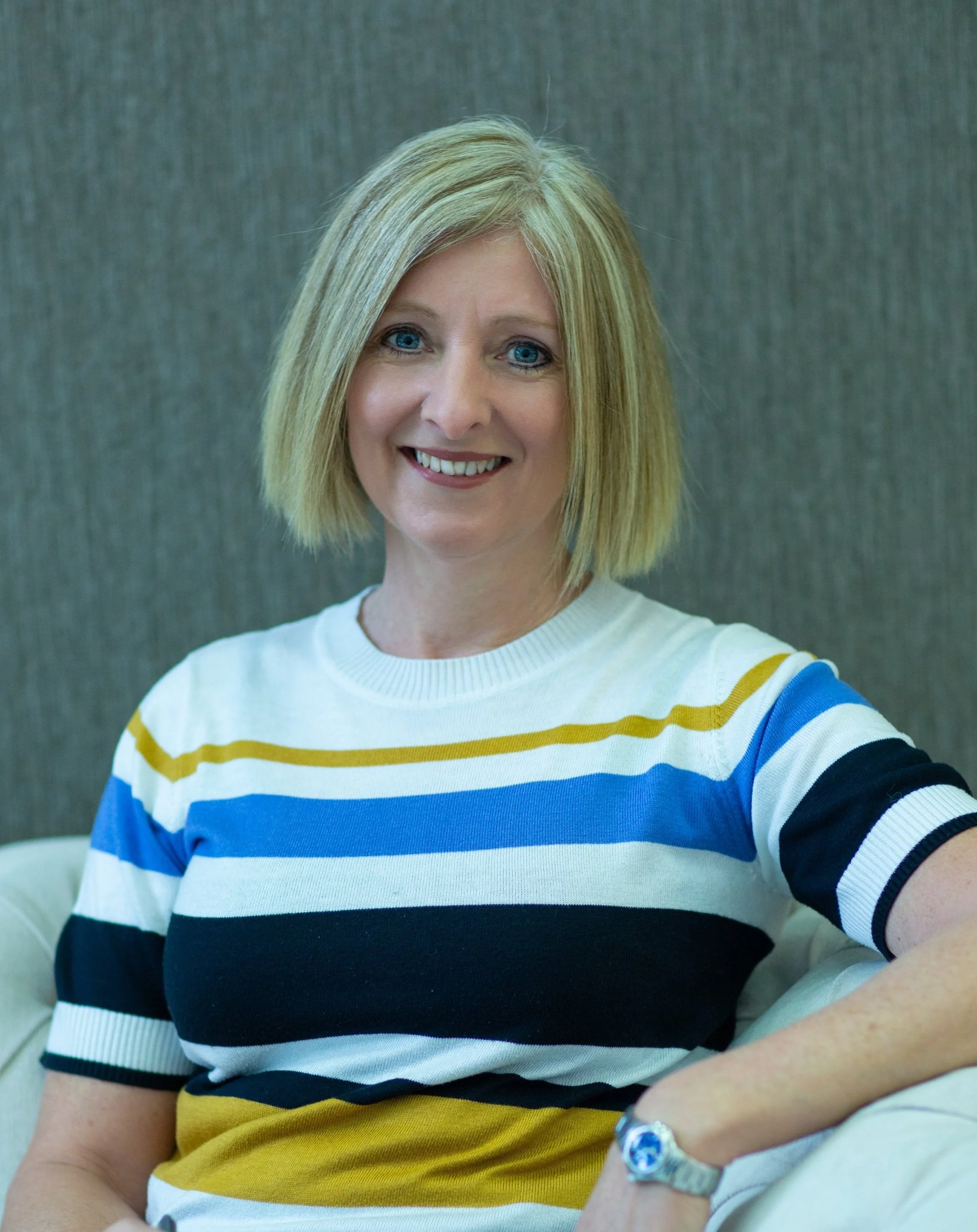 Annalie Graham - blonde haired woman in white and blue striped top smiling