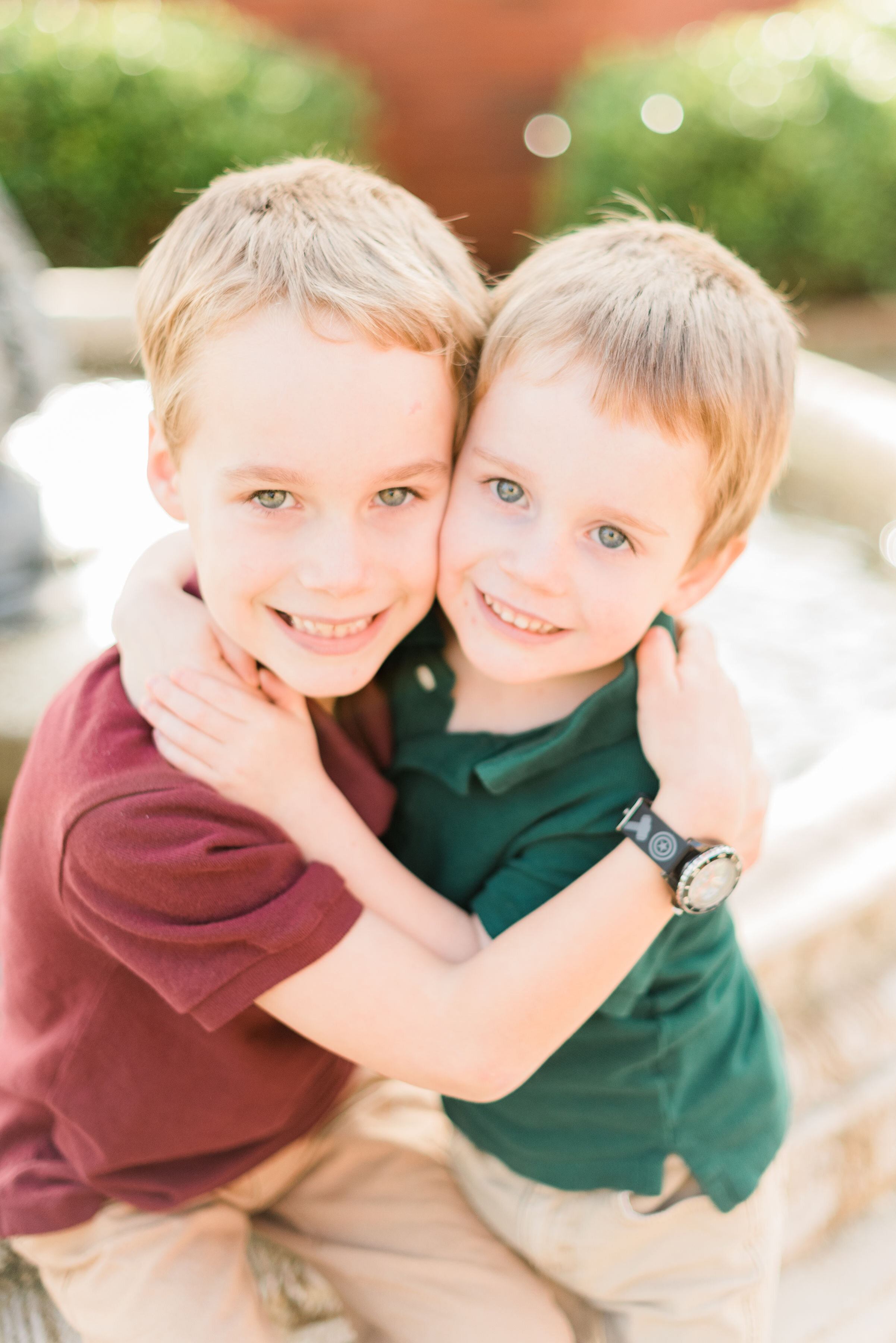  Two brothers give each other a hug and smile for the camera during a family photo session in Frederick, Maryland with Jacquie Erickson Photography. Brothers hug each other red and green polo outfit inspo family pictures individual shots Baltimore fa