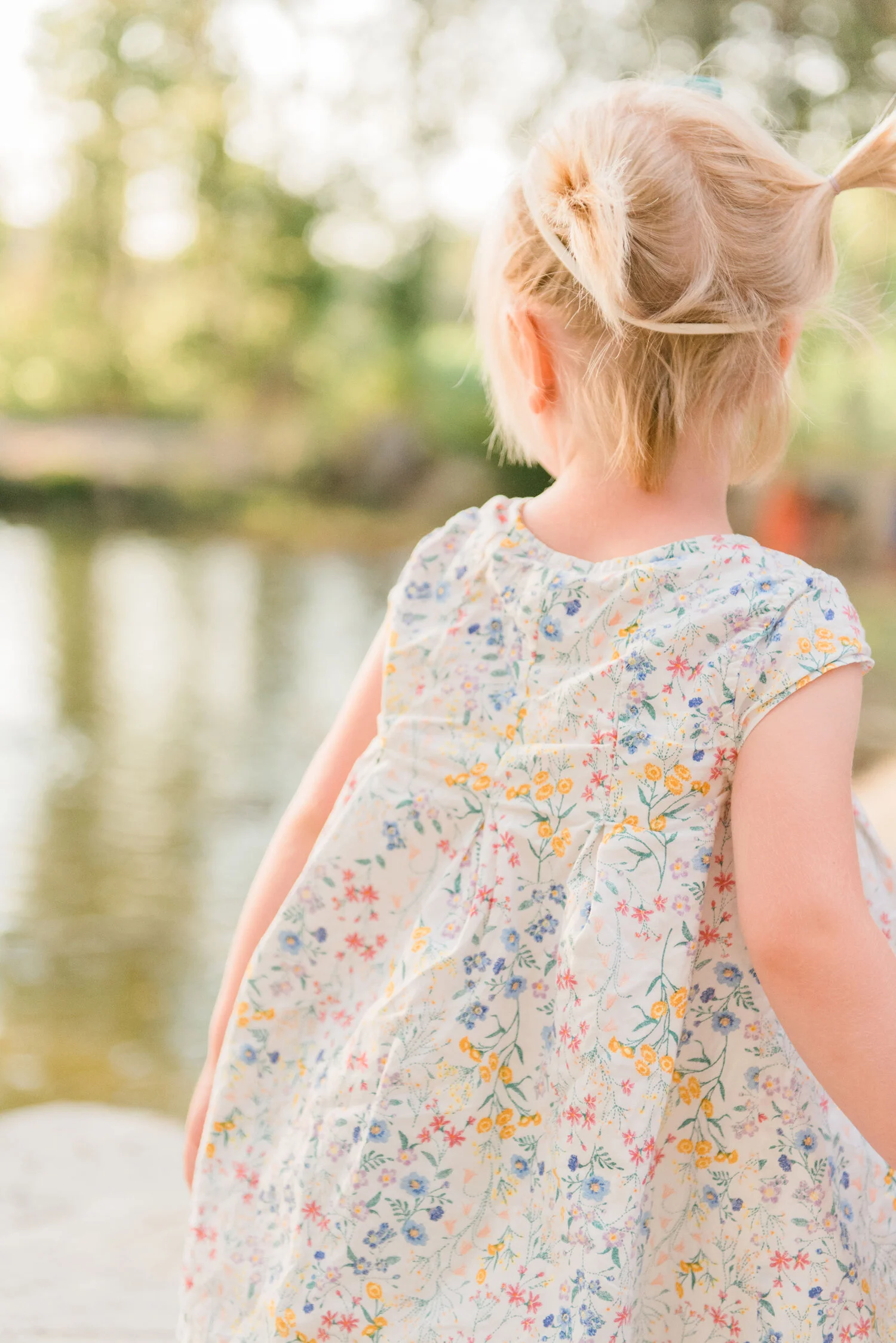 During this family photo session in Columbus, Maryland, Jacquie Erickson Photography captures up-close details of this little pony-tailed girl. toddler ponytail, toddler hairstyles, little girl cap sleeve floral spring dress, professional baltimore 