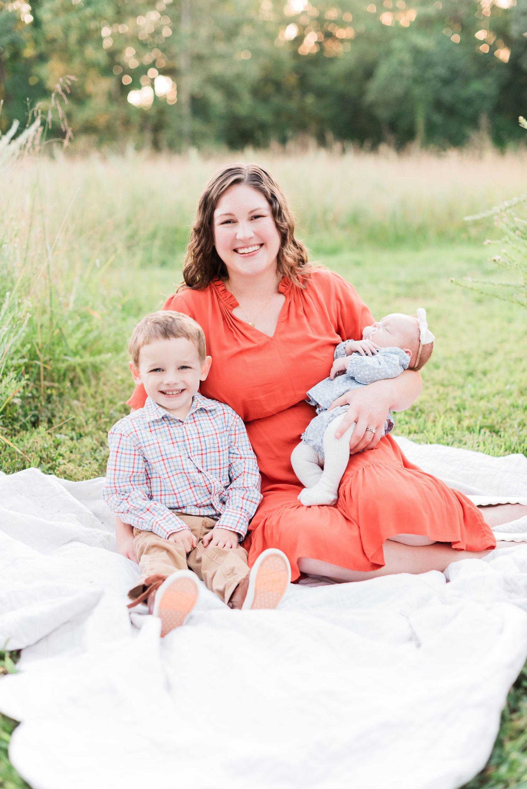    A sweet mom in a red dress poses with her babies during our fall family photo session. #marylandfamilyphotographer #findingafamilyphotographer #familyphotooutfits #semiformalphotooutfits #outdoorfamilysession #photoswithkids #georgiafamilyphotos #