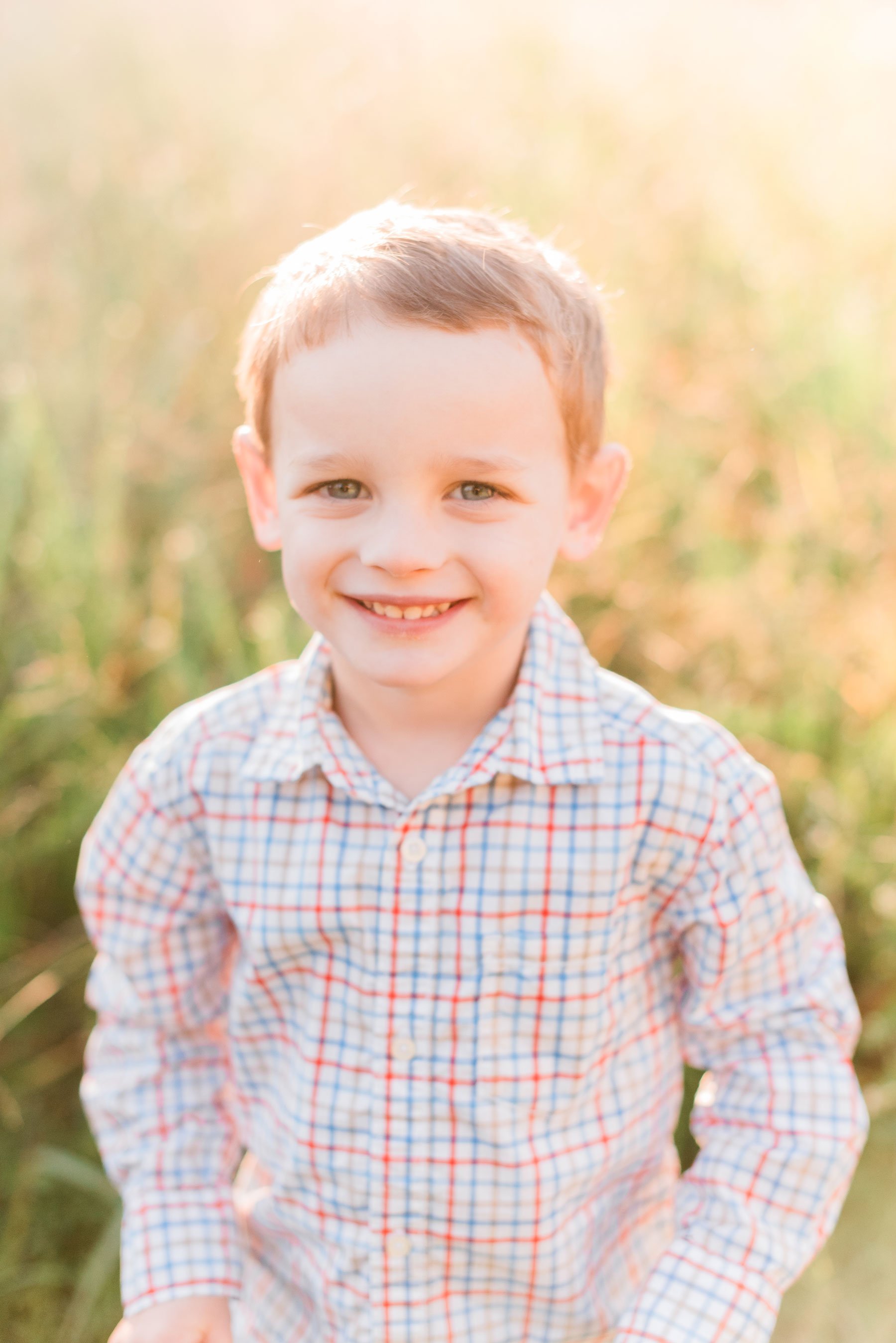    Henry smiles for his handsome solo portrait in his long sleeved button down shirt . #marylandfamilyphotographer #findingafamilyphotographer #familyphotooutfits #semiformalphotooutfits #outdoorfamilysession #photoswithkids #georgiafamilyphotos #sib