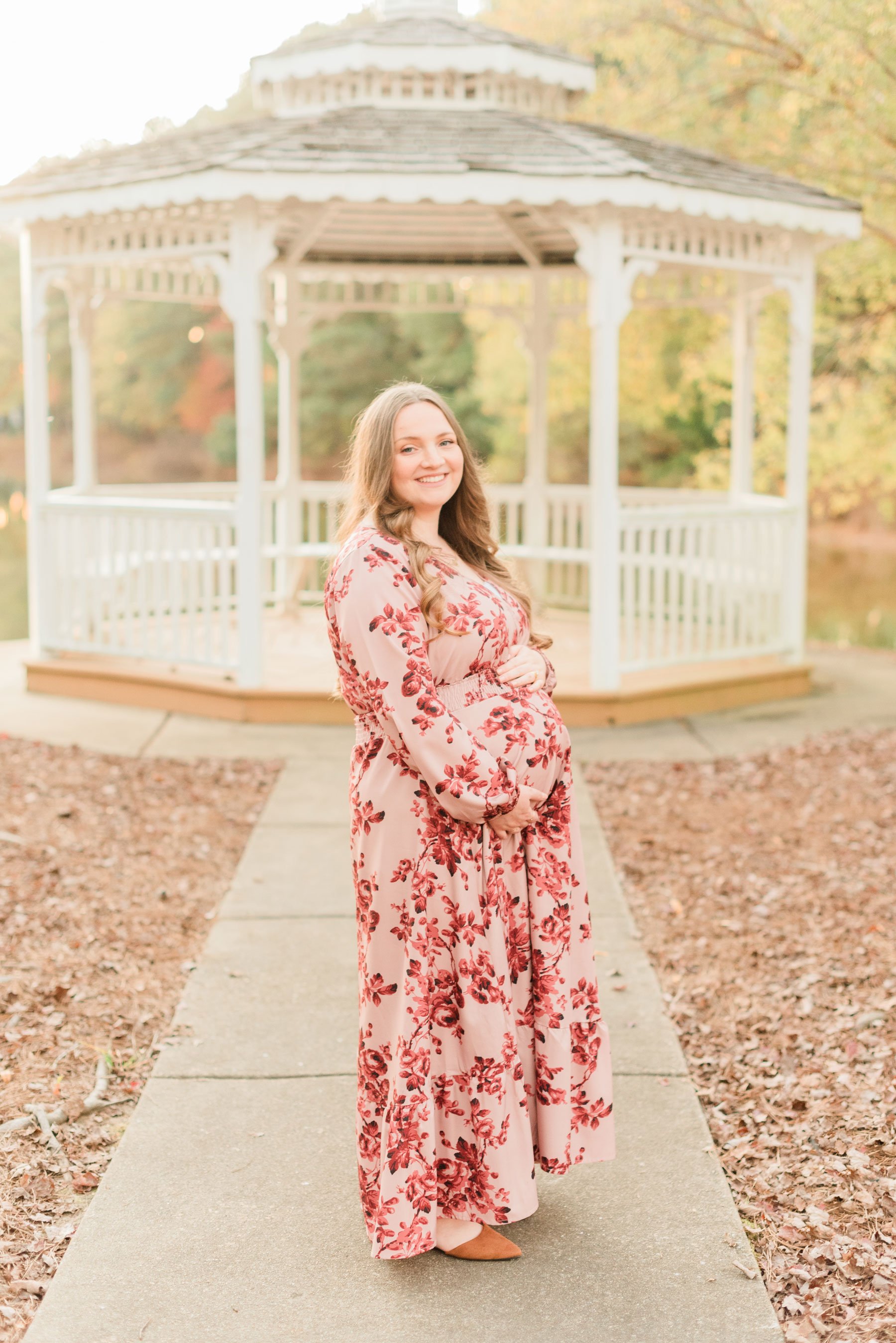  A pregnant woman stands in profile holding her pregnant belly during a fall maternity shoot. Georiga maternity photographer Peachtree City Fayetteville Senoia Newnan #familymaterintyphotos #pregnacyphotoshoot #atlantafamilyphotographer #jacquieerick